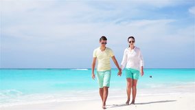 Young couple on white beach during summer vacation. Happy family enjoy their honeymoon. SLOW MOTION VIDEO.
