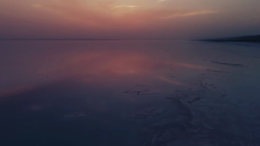 Sunset at salt lake Turkey. sunrise reflection on salt flat covered with water and clouds