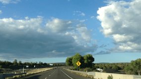 HD Video of group of motorcycle riders driving through the high desert on highway 17 towards Flagstaff, blue sky with big fluffy white clouds. 2X normal speed.