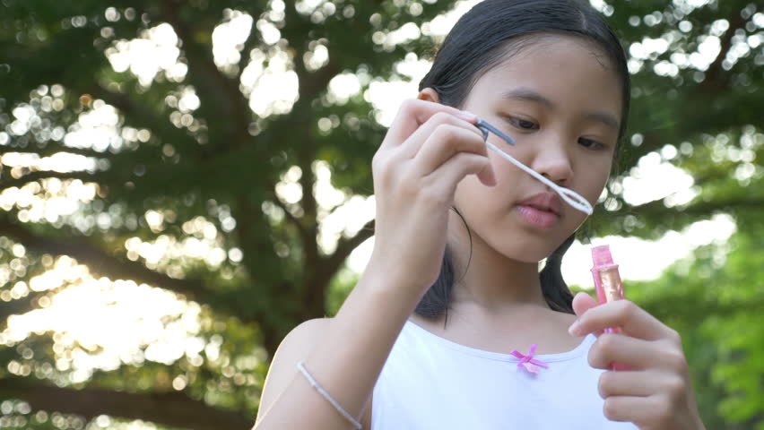 4K : Asian girl playing with soap bubbles, Outdoor having fun
