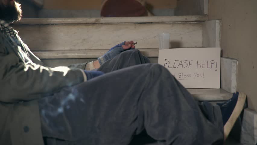 Homeless. Unemployed ,lonely Beggars smoking a cigarette on the stairs