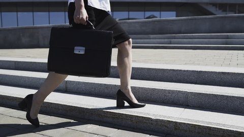 Business Woman in Formal Suit with Briefcase is Walking in City