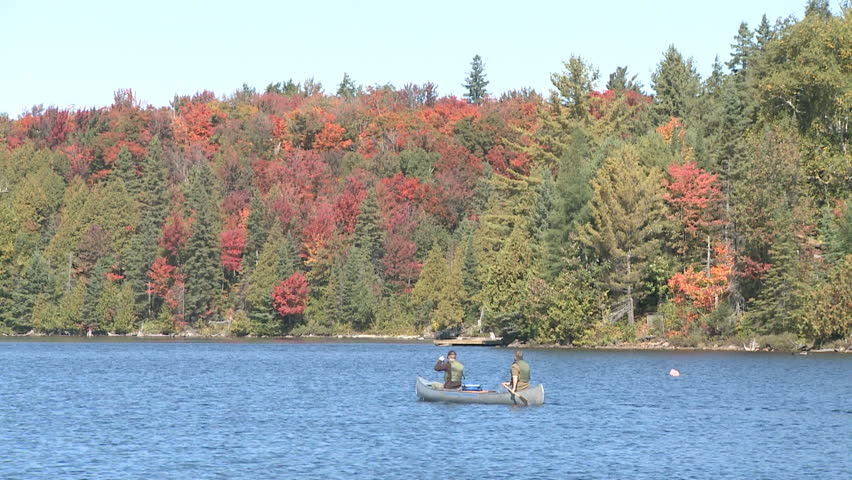 People boating with a canoe on a lake in a peaceful nature scene