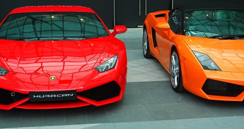 SINGAPORE - CIRCA AUG 2015: Pair of luxury sports cars in orange and red. parked on display at a Ferrari dealership in Singapore. 4k video