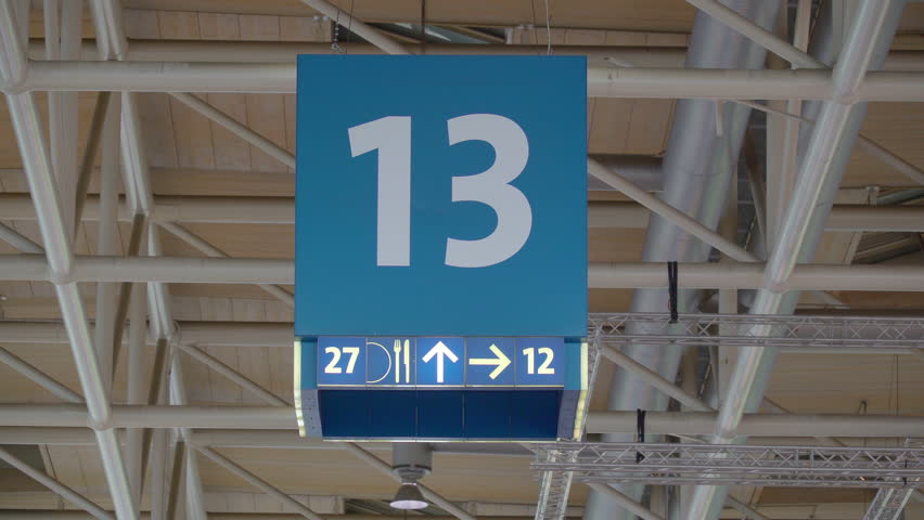 A number 13 lane number sign on the ceiling indicating that it is the 13th lane
