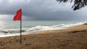 Storms season. Red warning flag on the beach - no swimming 