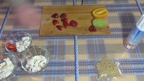Slicing strawberries. Half of the orange and kiwi lies on the cutting board. Whipped cream. A metal knife. Food video. Waffle cup. Making ice cream sundae: vanilla ice cream.