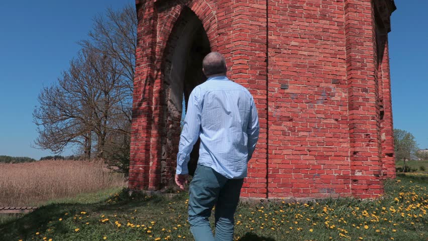 Man takes pictures near old tower