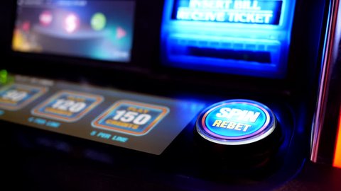 Coquitlam, BC, Canada - May 02, 2017 : Close up woman pressing spin button on slot machine inside Hard Rock Casino with 4k resolution