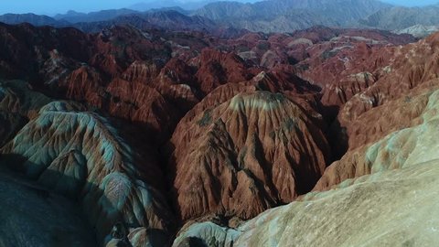 Flying a drone over the colorful Zhangye Rainbow Mountains; aerial view on sandstone hills and mountain chains covered by amazing pattern. Part 5 of a 5 part series-can be merged to 1 continuous movie