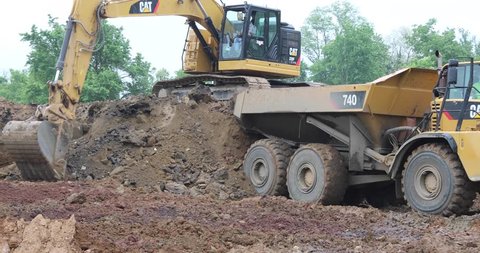 New Cumberland, PA, USA - May 22, 2017 : Heavy equipment being used to move mound of dirt at industrial site.