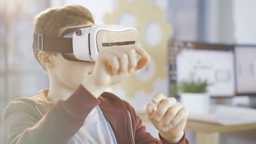 In a Computer Science Class Boy Wearing Virtual Reality Headset Works on a Programing Project. Shot on RED EPIC-W 8K Helium Cinema Camera. Royalty-Free Stock Footage #27062098