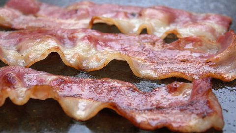 Close-up of a slice of bacon fried on a hot grill
