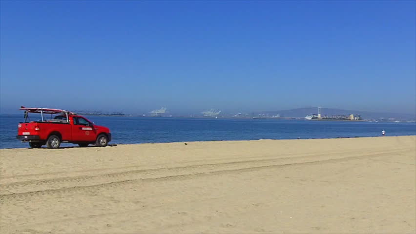 LONG BEACH, CA - AUGUST 5: A lifeguard truck patrols the beach on August 5, 2012