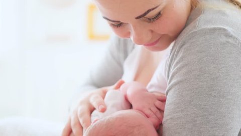 Breast feeding, breastfeeding concept. Young happy Mother feeding her Newborn baby.  mother breastfeeding, hugging and kissing her hew born child. Lactation infant concept.  4K UHD video 3840X2160
