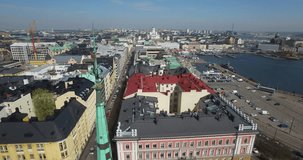 Aerial view drone footage of Helsinki old church, bay area with boats and road traffic near sea terminal and harbour with city skyline and Baltic Sea view in the capital of Finland, northern Europe