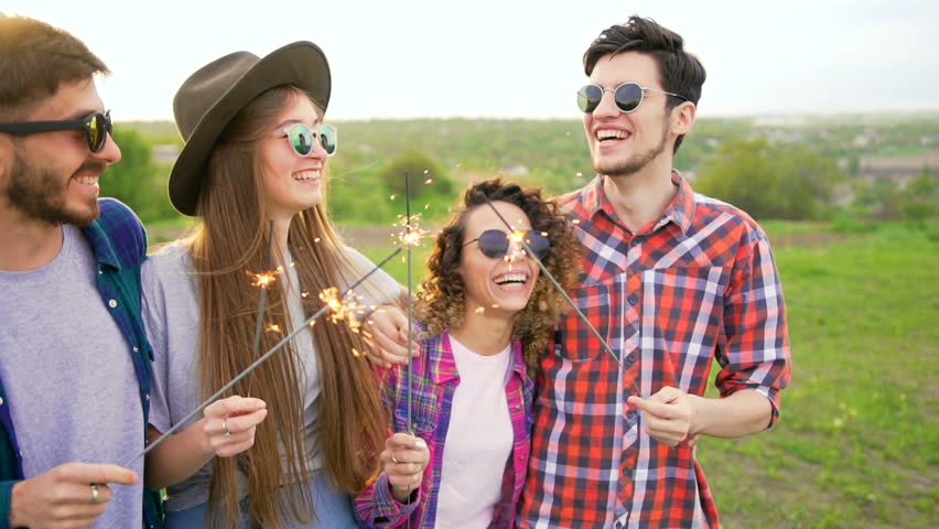 Group of four happy smiling friends walks with sparklers at slow motion. Summer leisure concept. Two women and two men Royalty-Free Stock Footage #27073783