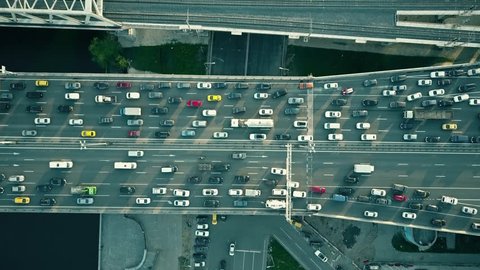 Aerial top down view of traffic jam on a car bridge and moving train. 4K video