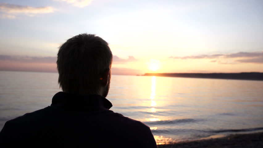 Man walking on the beach in slow motion. silhouette of a boy moving along the coastline. A guy walk in the evening at sunset. Silhouette 20s european male outdoor. Person move in HD 1080P.