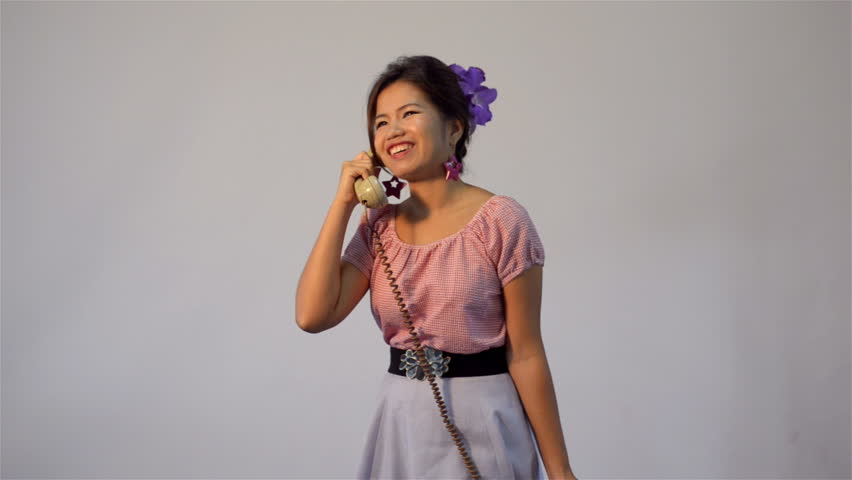Asian woman in vintage style fashion, having an happy conversation on the phone,