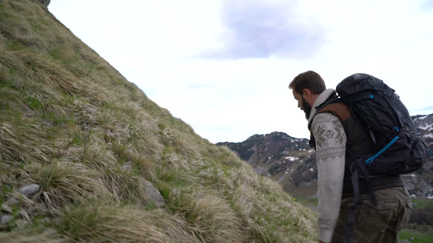 Hiker climbing the mountain slopes