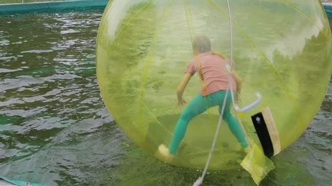 Editorial. Omsk,Russia - May 20. 2017. Girl teenager in zorb bubble ball swimming in pool