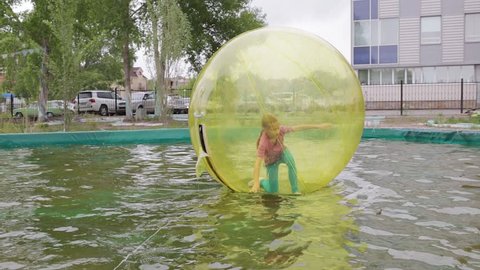 Editorial. Omsk,Russia - May 20. 2017. Girl teenager in zorb bubble ball swimming in pool