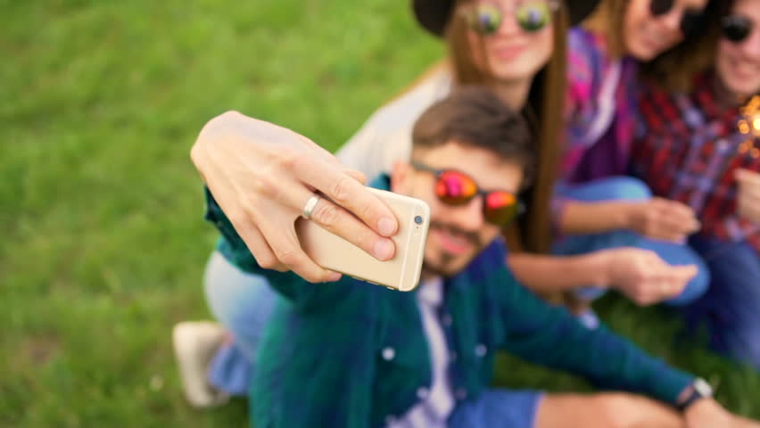 Portrait of four happy hipsters while they making selfie with sparklers on a smart phone. Cheerful people. Summer lifestyle Royalty-Free Stock Footage #27095455