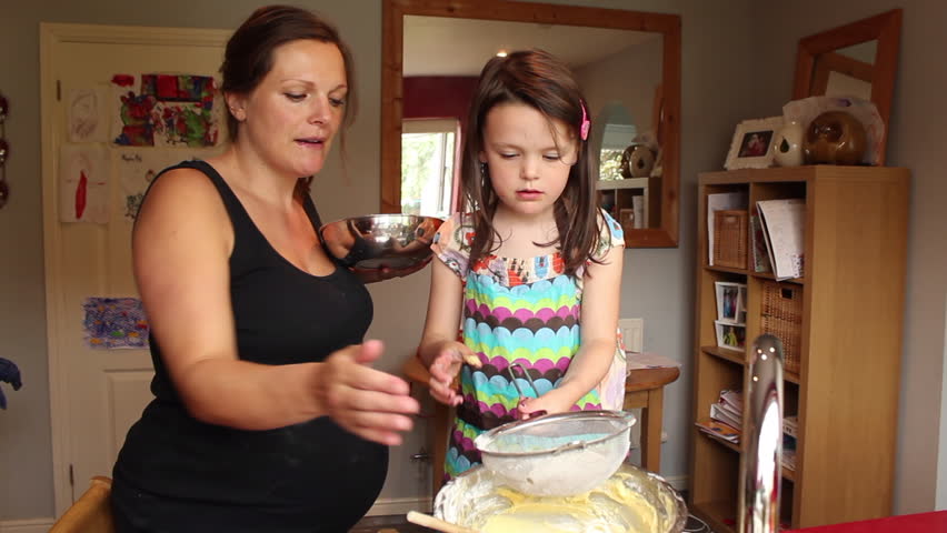 mother teaching young daughter how cook: стоковое видео (без