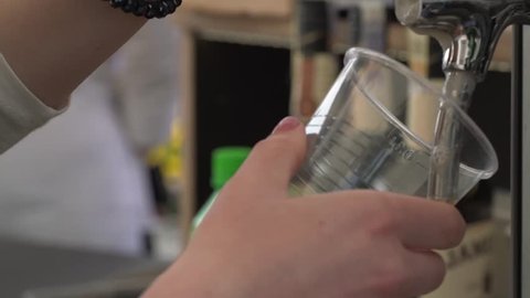 Tapping beer into a plastic cup.