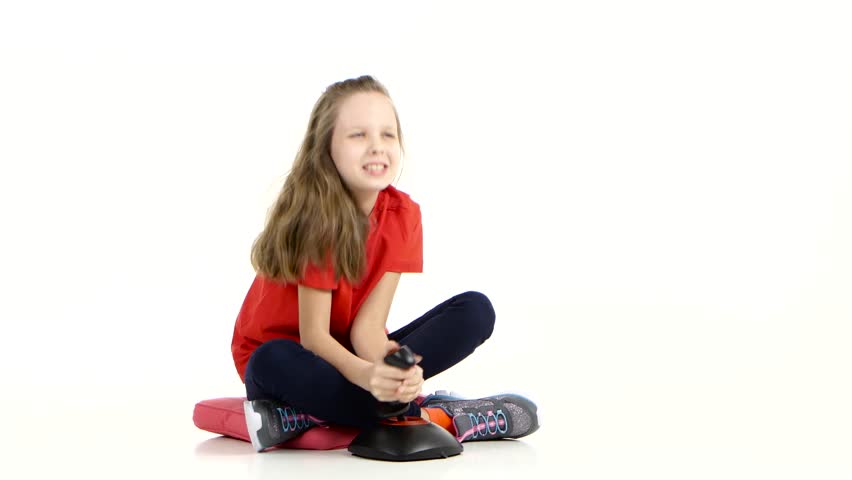 Child plays with joystick in online game sitting on floor