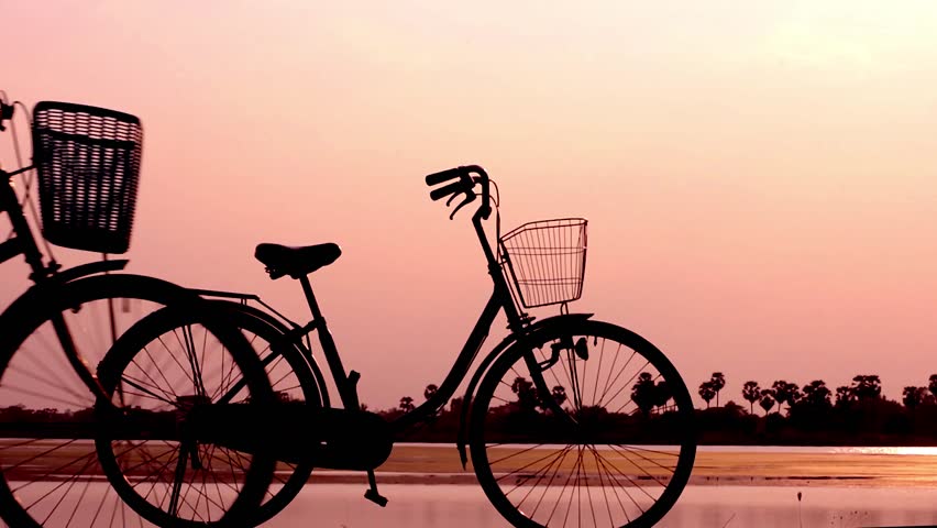 people exercise with bicycle in sunset