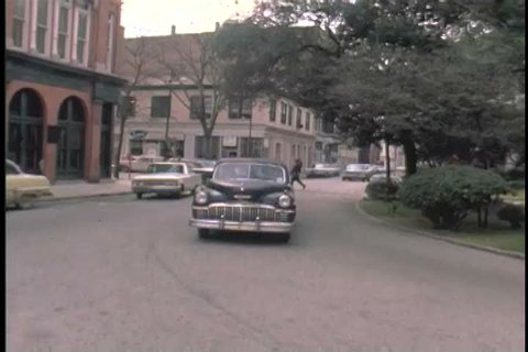 1960s: A 1950s worn out Cadillac rolls up to a US Post Office and three African American women exit and_ walk to the front door in the 1960s.