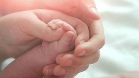 Family Baby Hands together. Father and Mother Holding Newborn baby hand. Child Hand Closeup into Parents hands together. New life. Adoption concept. 4K UHD video 3840X2160