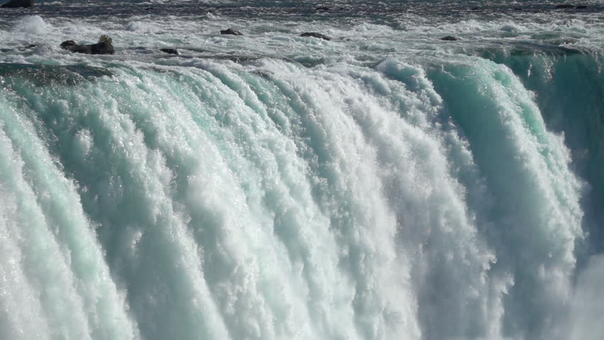 SLOW MOTION, CLOSE UP: Powerful raging whitewater waterfall falling forcefully over a rocky edge. Crystal clear glacier water stream dropping over the cliff. Misty majestic Niagara Falls river rapids