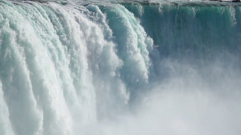 SLOW MOTION, CLOSE UP: Powerful raging whitewater waterfall falling forcefully over a rocky edge. Crystal clear glacier water stream dropping over the cliff. Misty majestic Niagara Falls river rapids