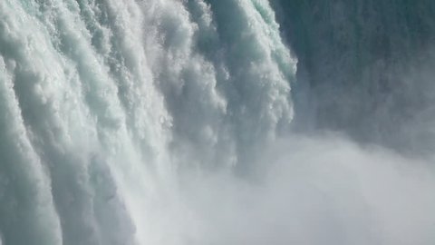 SLOW MOTION, CLOSE UP: Powerful raging whitewater waterfall falling forcefully over a rocky edge. Crystal clear glacier water stream dropping over the cliff. Misty majestic Niagara Falls river rapids