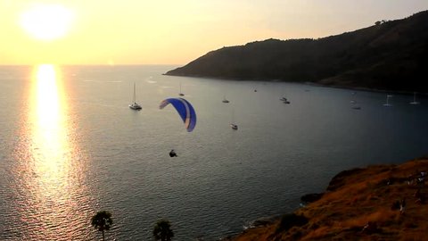 Man paragliding at splendid sunset by the sea in Phuket island, Thailand
