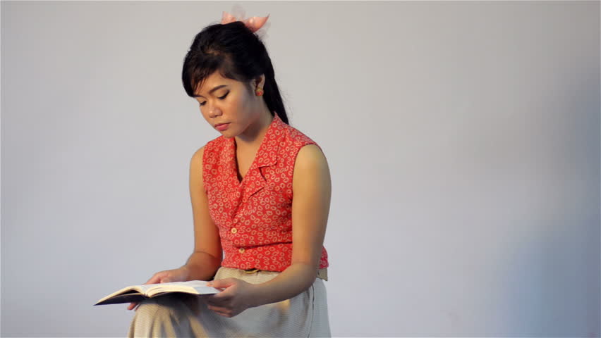 Young Asian woman thinking while reading a book/ the bible - dolly tracking