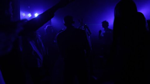 People dance in the club in the dark.