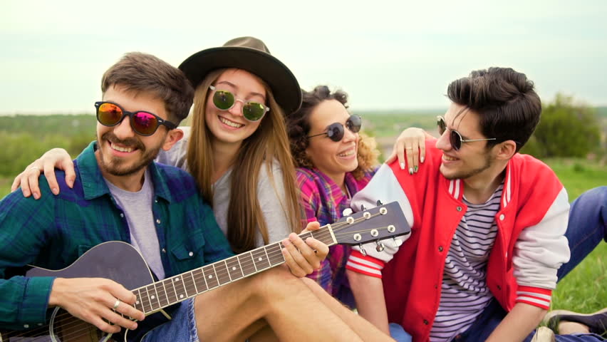 Group of young people at picnic, while they plays guitar and sings. Close up steadicam Royalty-Free Stock Footage #27136549