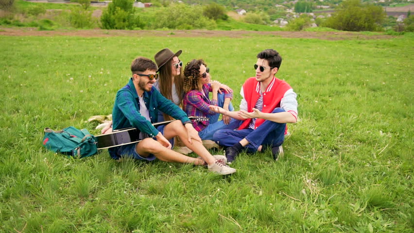 Young man tell funny stories to his friends. Other man gives five. Handsome women laughing about it. Summer lifestyle Royalty-Free Stock Footage #27138628