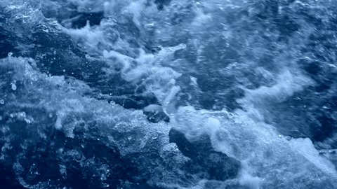 Dark blue water with white foam rising. Slow Motion 180 fps