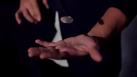 Trick flying coin. Hands of a magician. Levitation / Hands magician show a trick with a coin. Trick flying coin