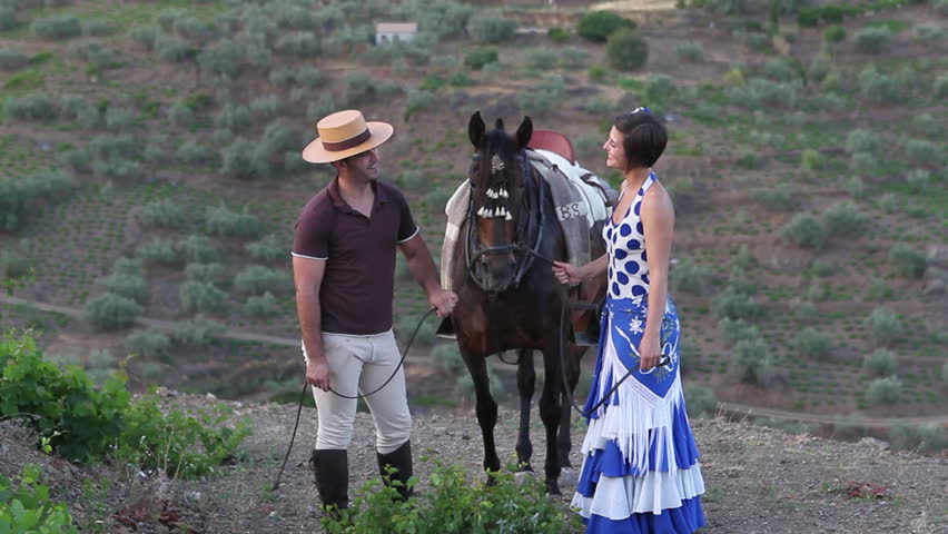 Couple chatting and standing next to a horse