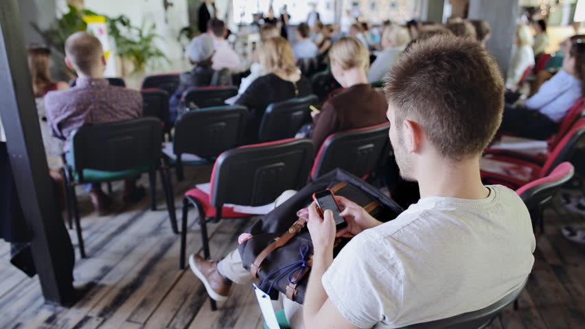 Young man look as the speaker tells the speech at business conference