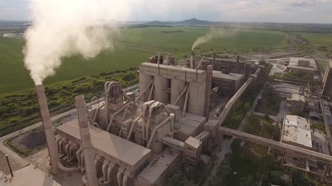 Large industrial concrete cement building plantin  Russia Spassk-Dalny Vladivostok, Russia Primorsky krai regional center. Smoke tube pollution. Aerial drone from above 4k footage. Summer sunny day.