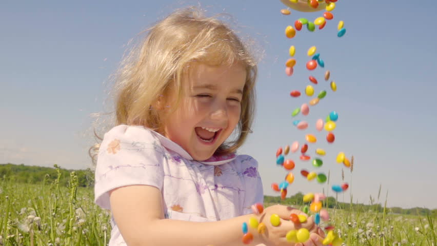 This girl is having pleasure playing with the candies.