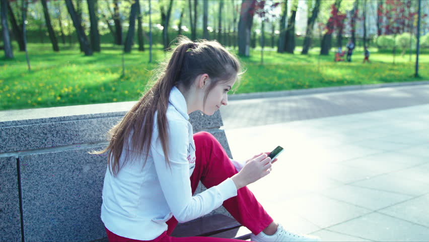 Girl listening to music sitting on a bench