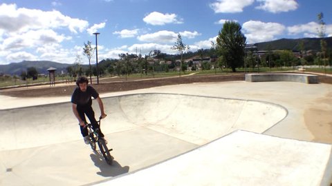 BMX bike stunts in skateboard park on a sunny day. Stock Video